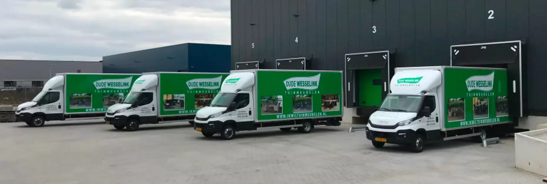 De bezorgwagens van Oude Wesselink Tuinmeubelen voor het magazijn in Enter